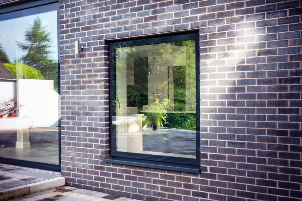 Large pane aluminium Lumi window on a brick home