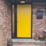 external view of installation of yellow composite door with black frame