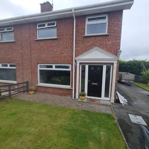 black front door installation with white upvc windows