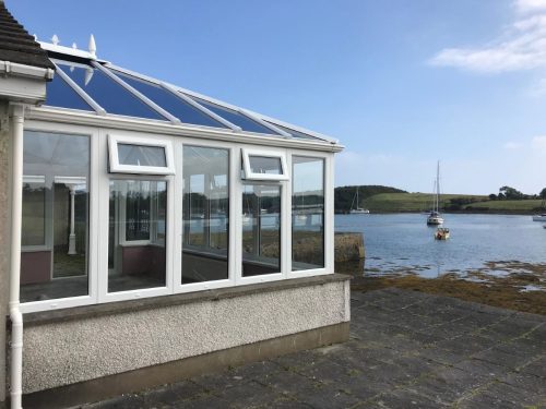 newly installed white upvc conservatory with a sea view