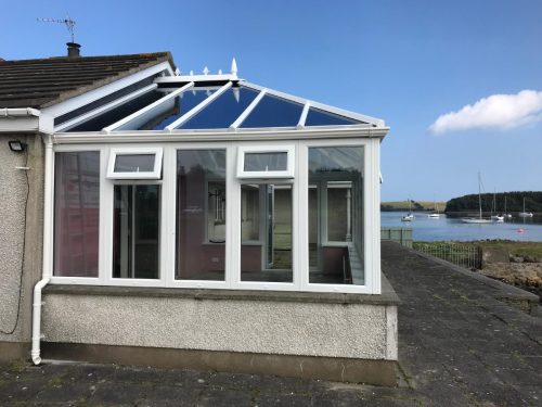 newly installed white upvc conservatory with a sea view