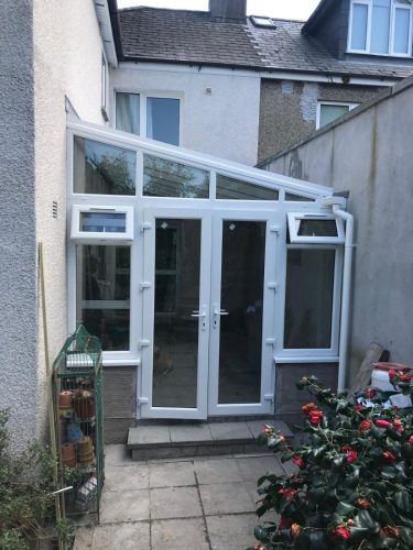 white upvc conservatory installation with white upvc french doors; making use of unused space in the back garden